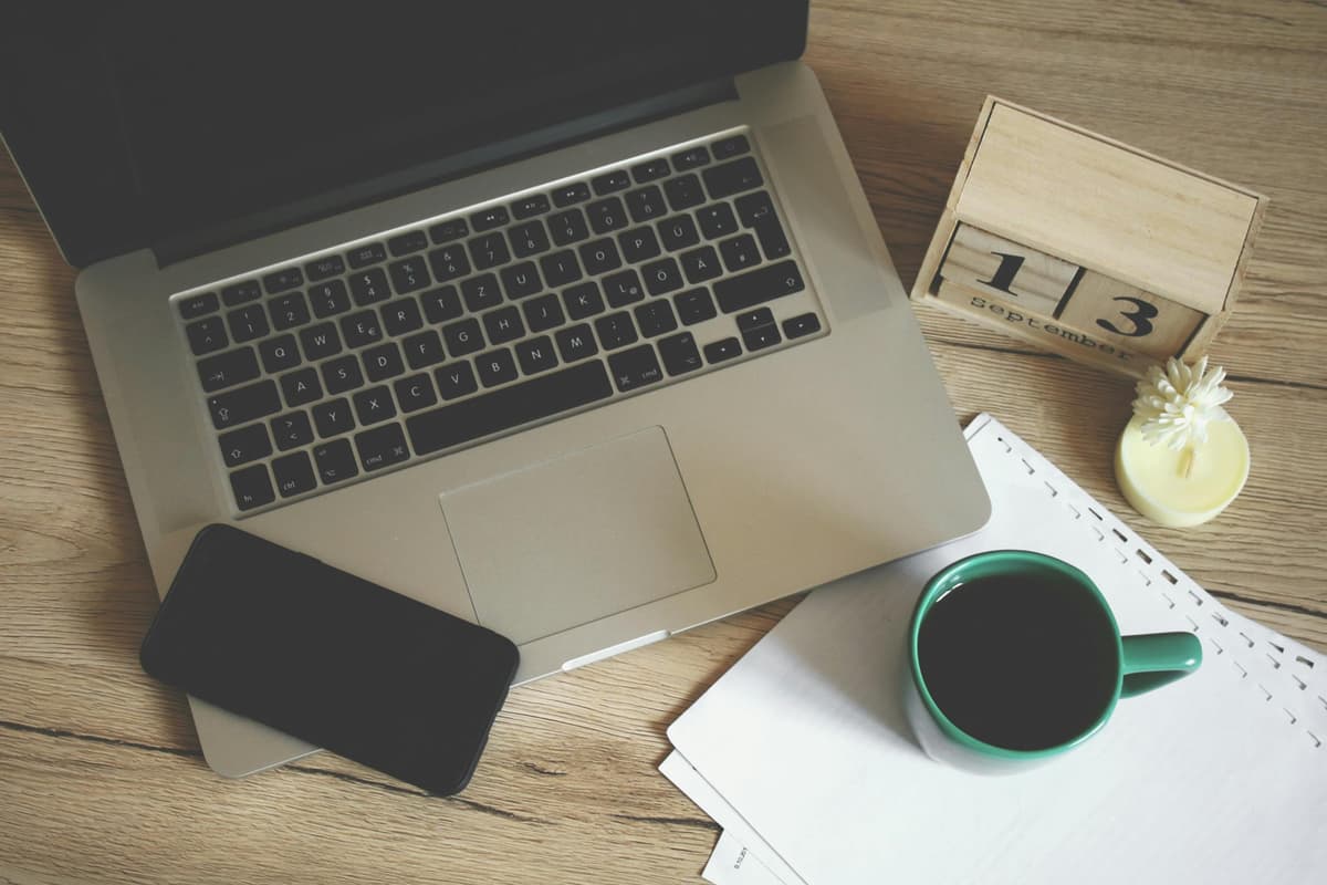 Laptop, coffee, and phone on desk