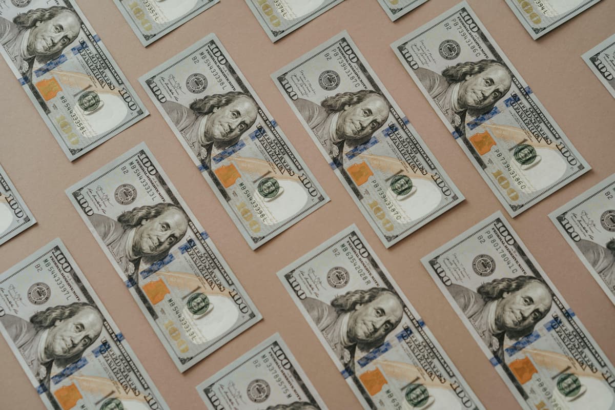 Scattered hundred dollar bills representing financial mastery